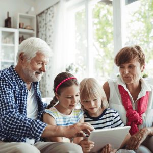 Grandparent on mobile device with grandkids.