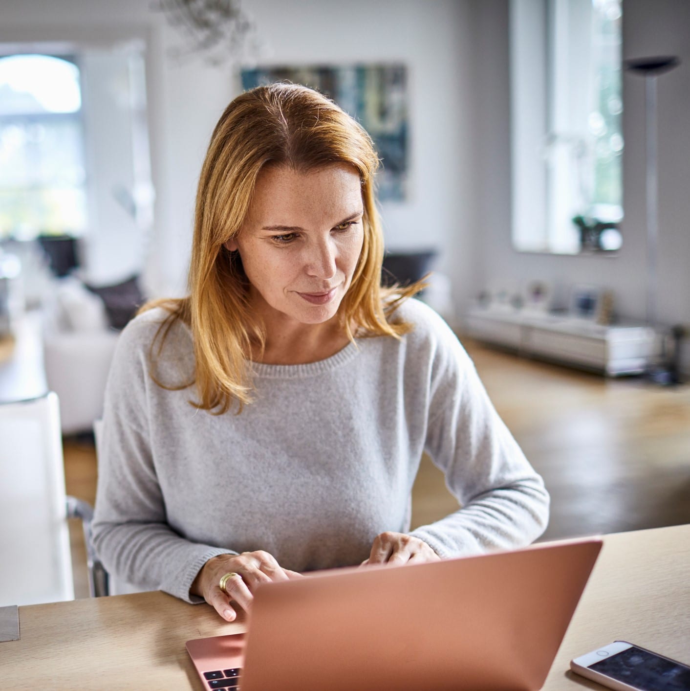 Woman using laptop on table at home